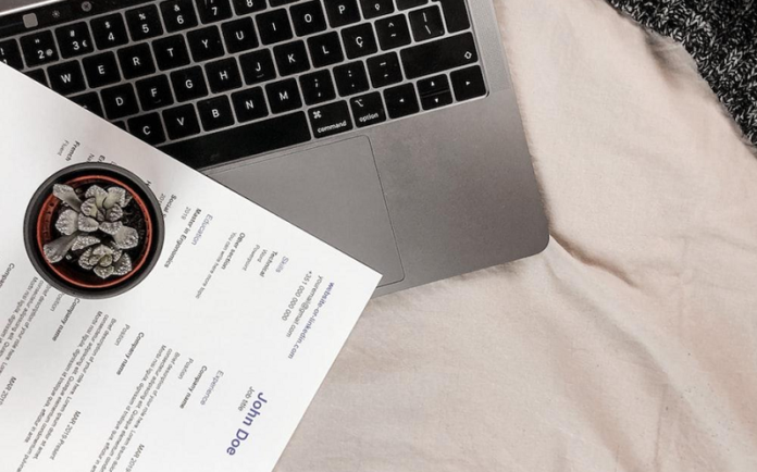 Resume laying down on the table with a laptop